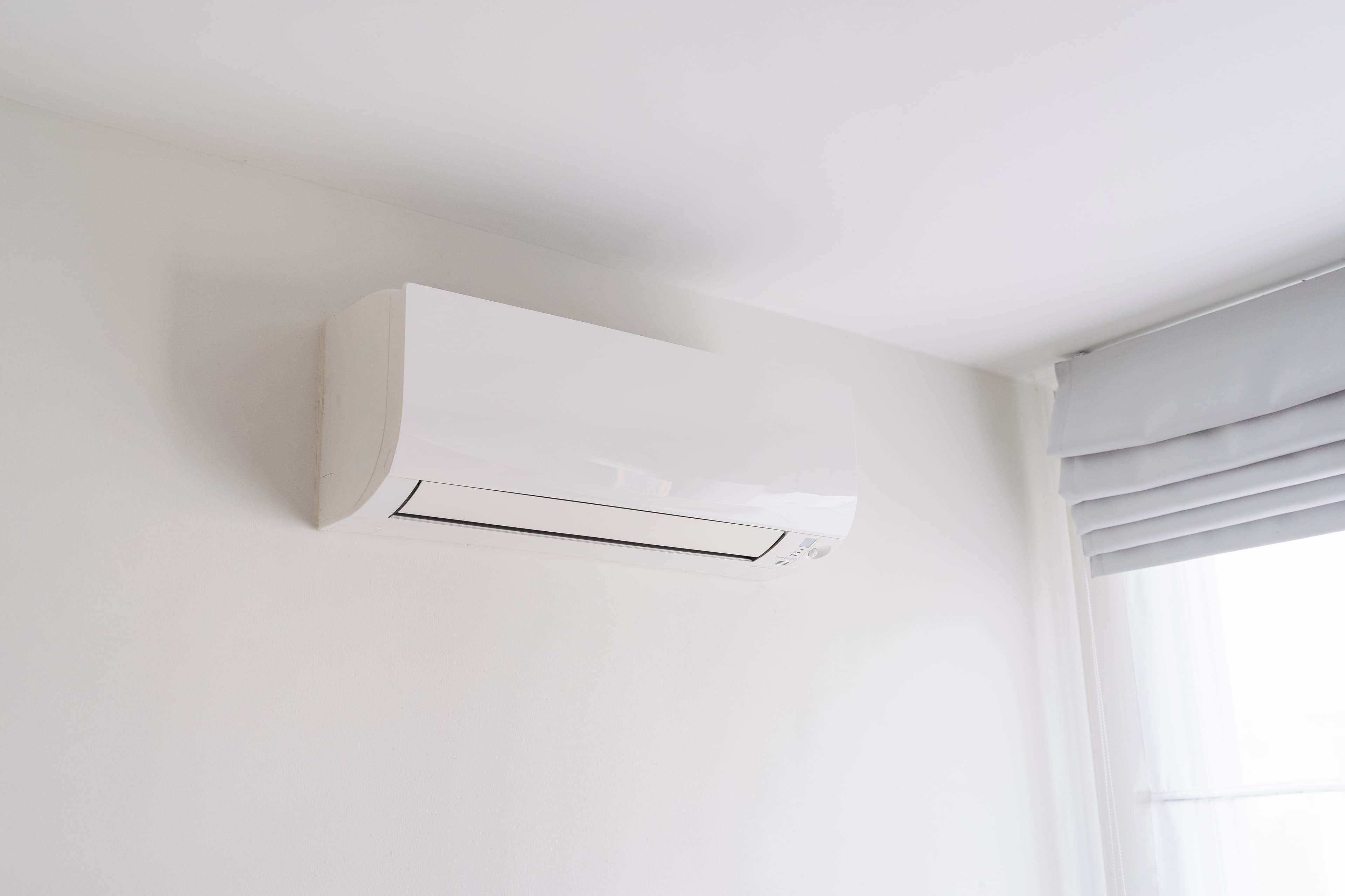 Modern wall-mounted air conditioner in a bright, minimalist room.