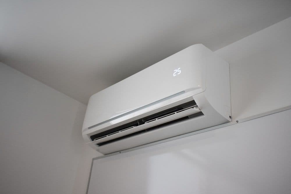 Modern wall-mounted air conditioner displaying temperature setting of 25 degrees Celsius.